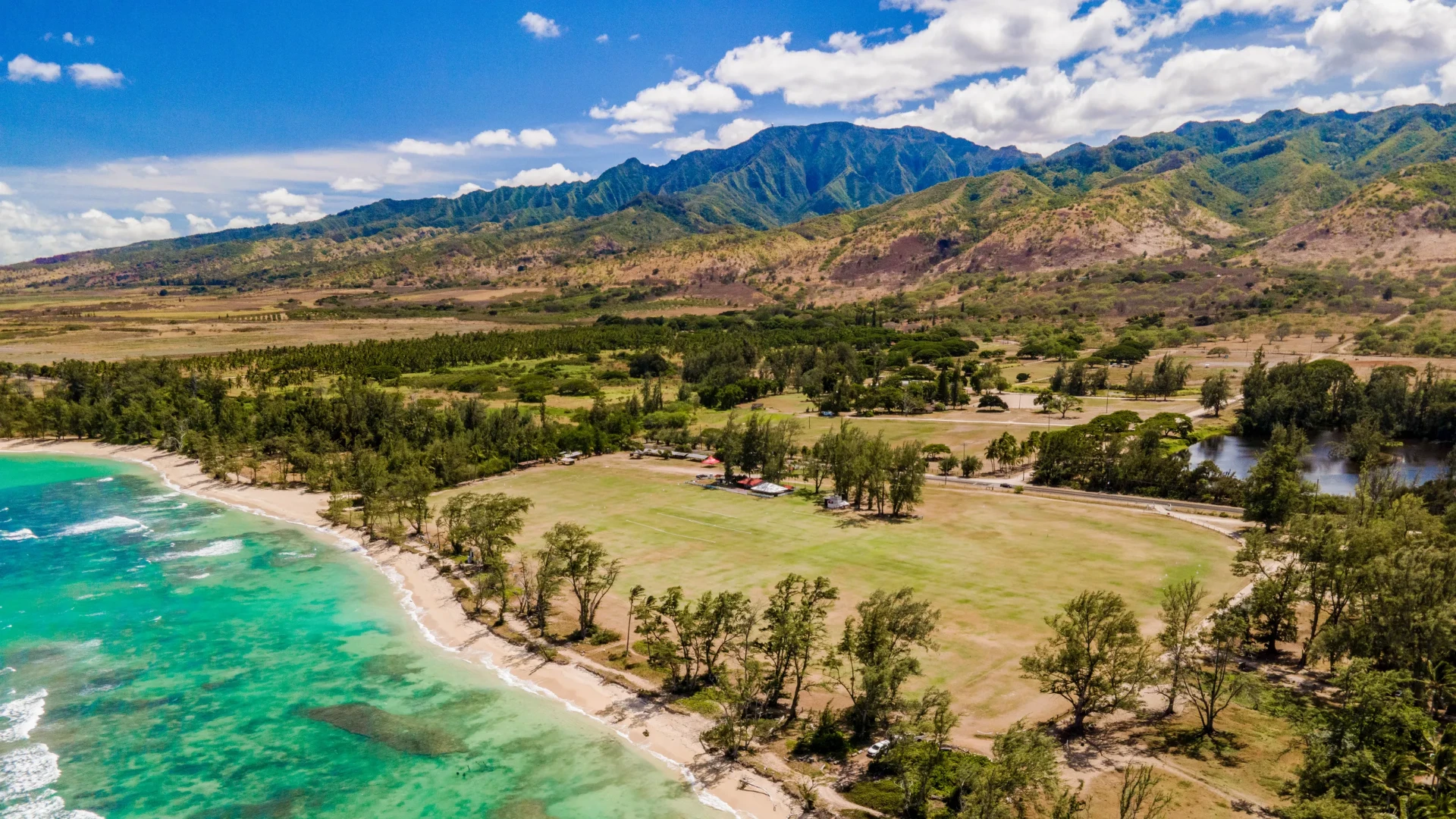 Cinematic aerial view of the Hawaiian island of Oahu coastline at golden hour